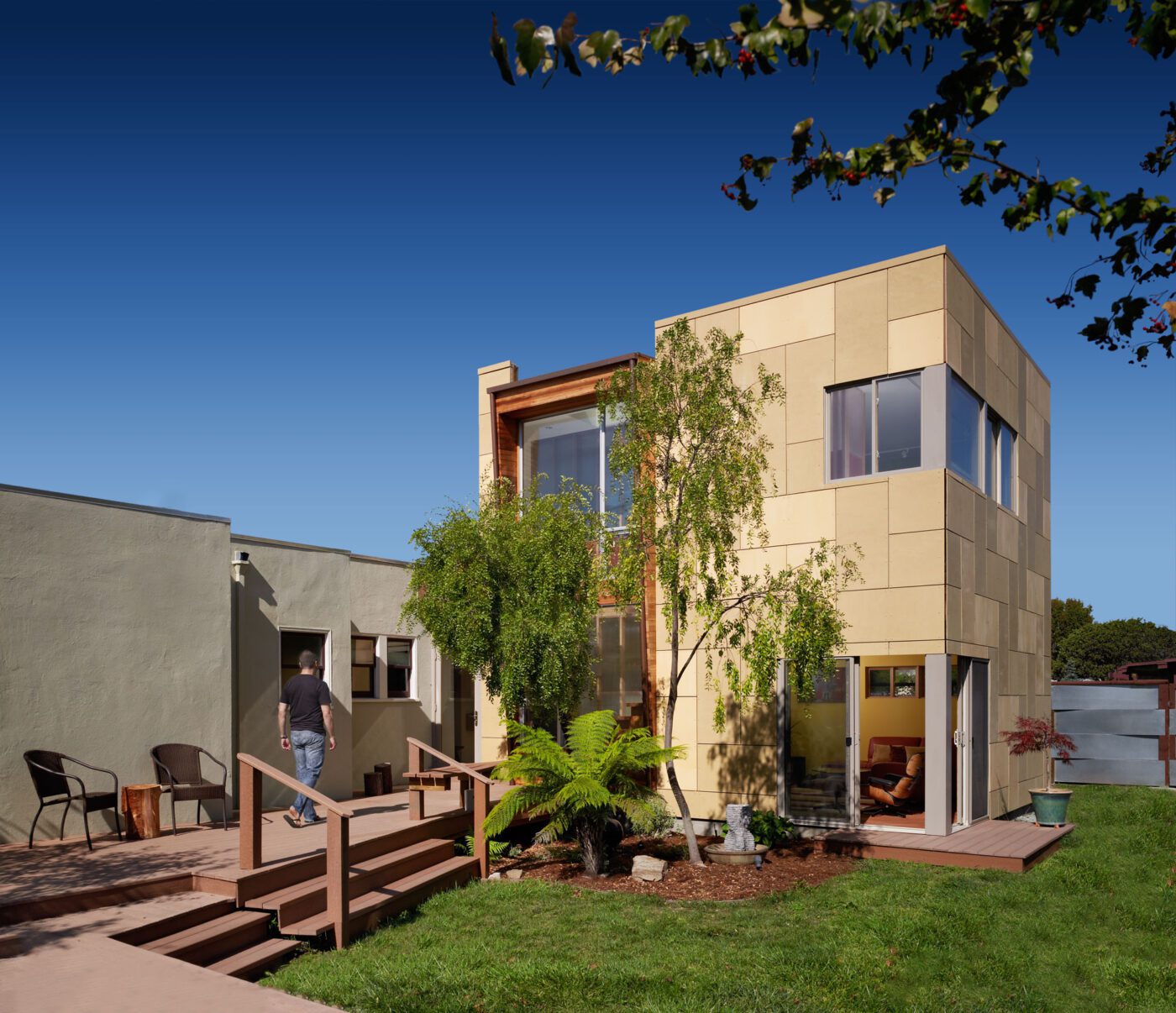 Corner View Modern Home Addition Berkeley with back yard and man walking on deck