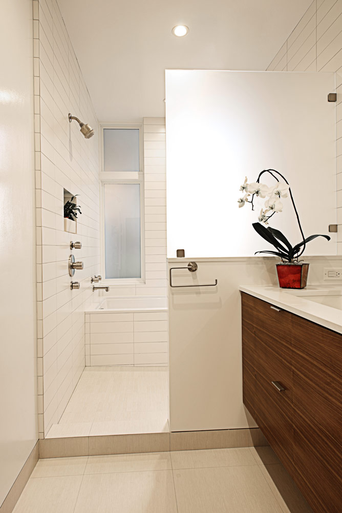modern white bathroom renovation with wood sink and orchid