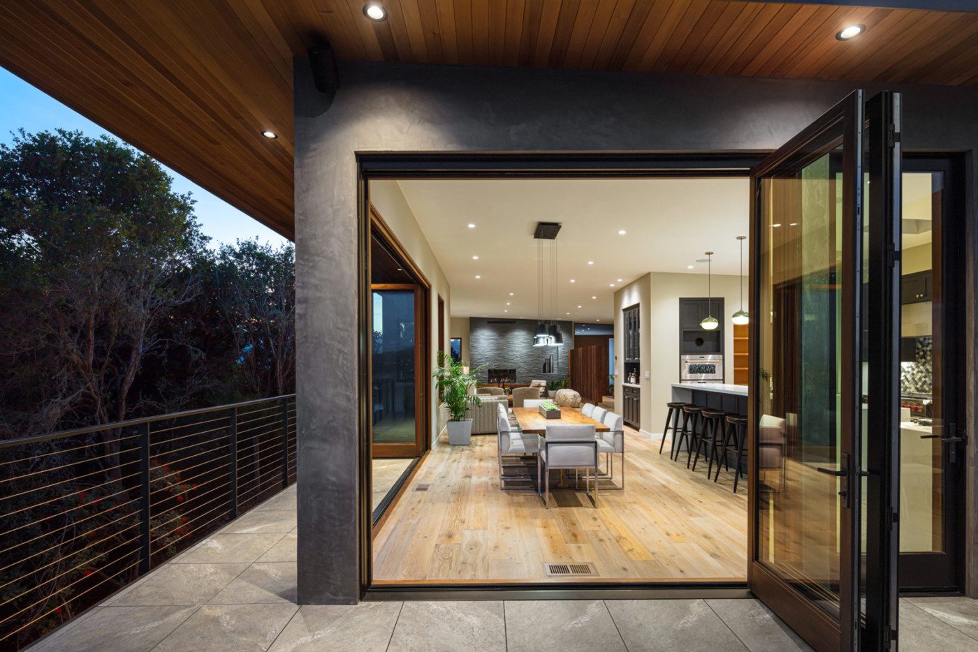 Open Plan Kitchen with Accordion Doors Opening to Deck