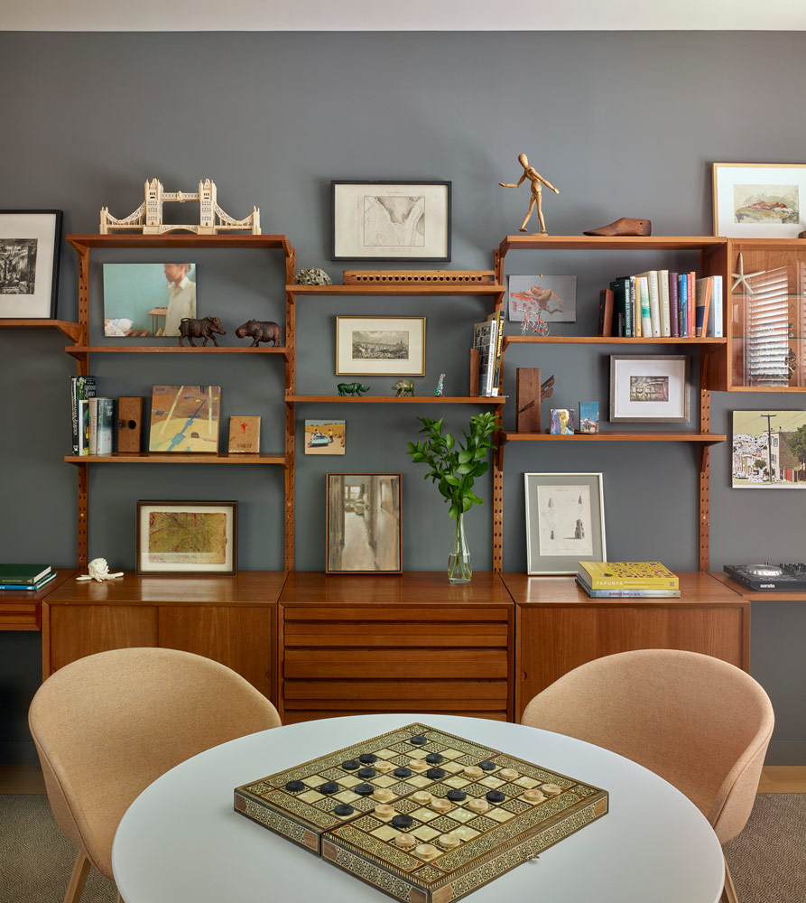 chess set in game room with wooden shelf and grey walls