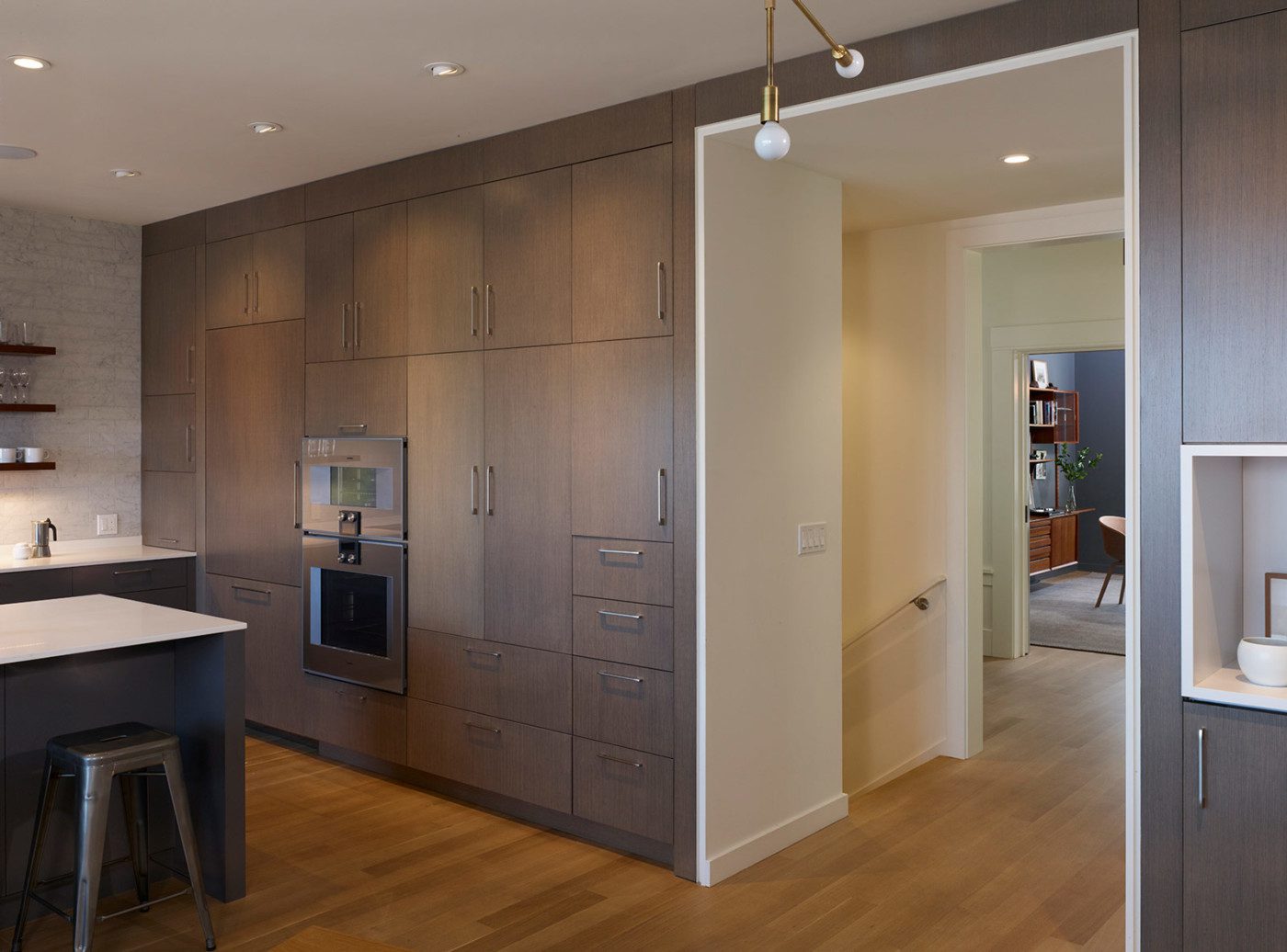 wall of dark cabinetry in the kitchen offers maximal storage in noe valley renovation