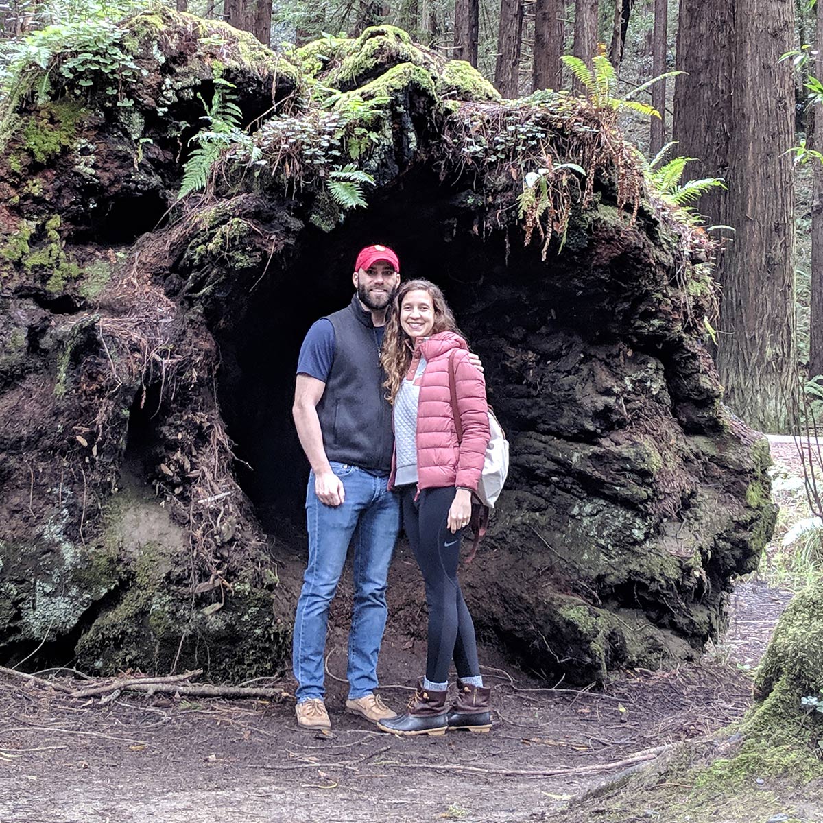 Camila with her husband hiking in woods