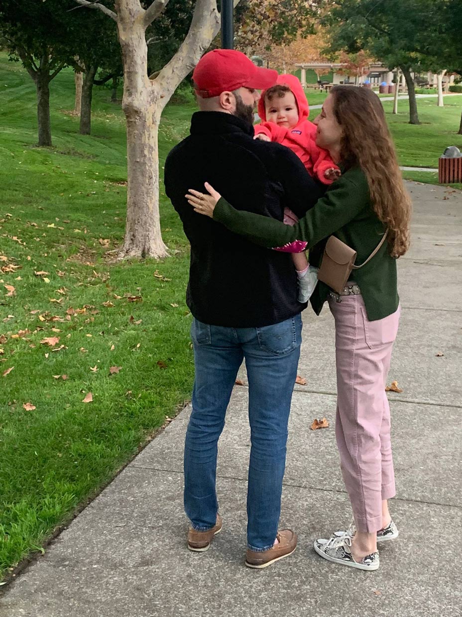 Camila with her husband and baby in a park