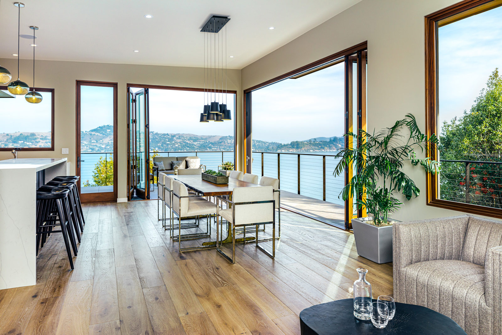 Modern home dining room with open plan kitchen view of the bay
