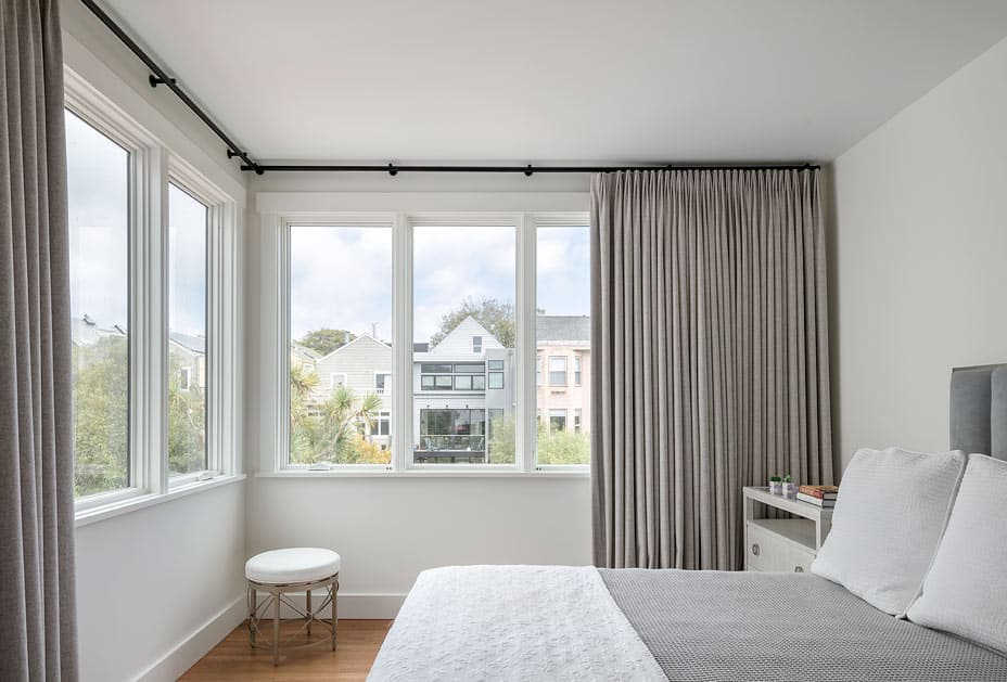 grey and white bedroom with large windows and views