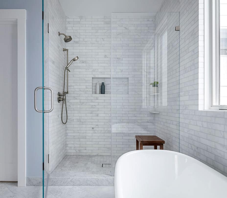grey tiled shower and modern freestanding white bathtub and rustic bench in San Francisco renovation
