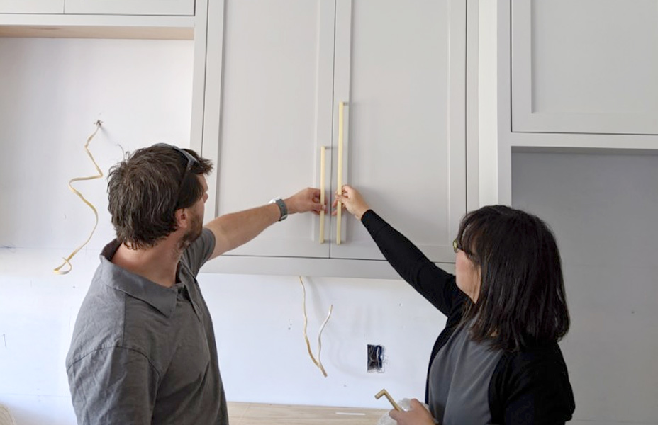 two people choosing cabinet pulls as part of kitchen remodel