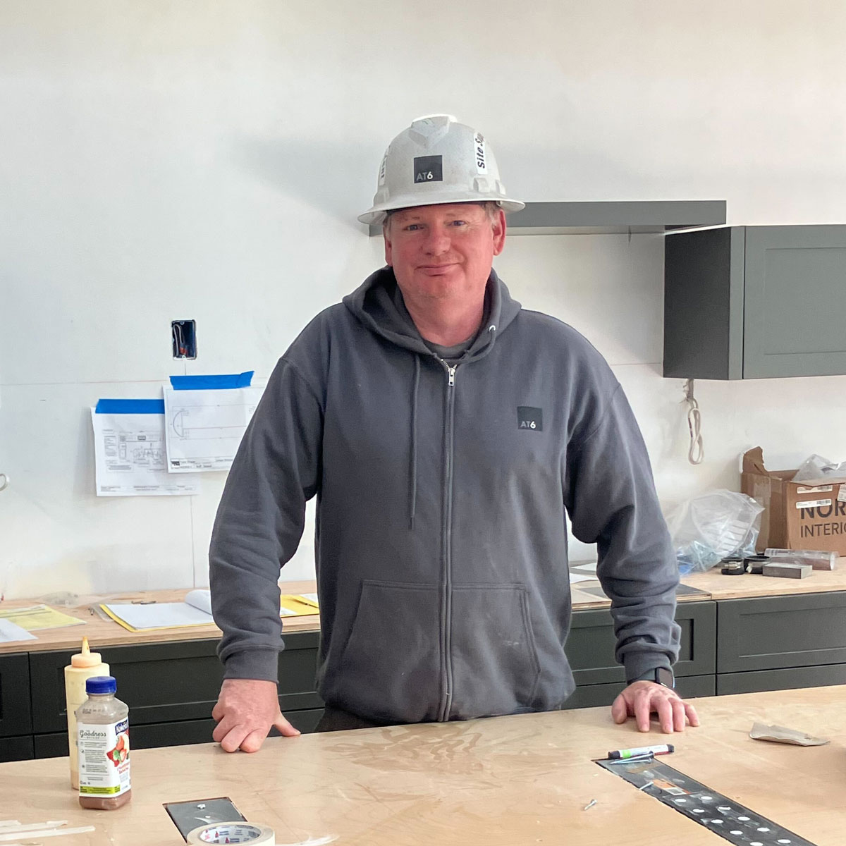 Anthony Gilleece on construction site with construction hat and tools