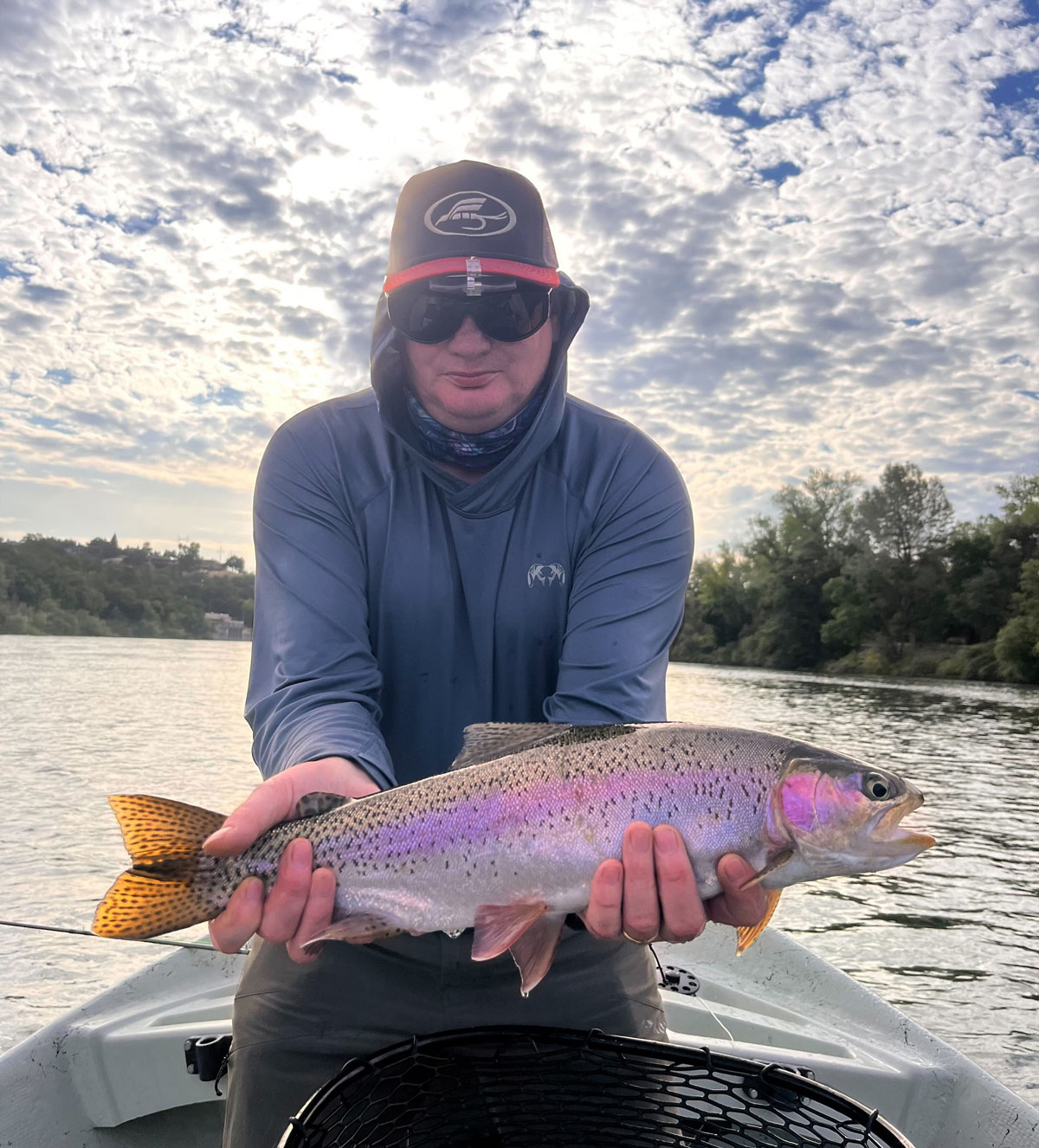 Anthony Gilleece in a boat on a lake with the fish he caught