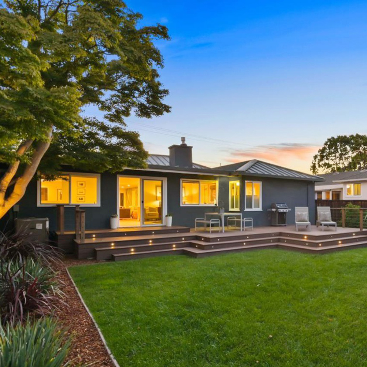 Night image of exterior of bay area home with backyard
