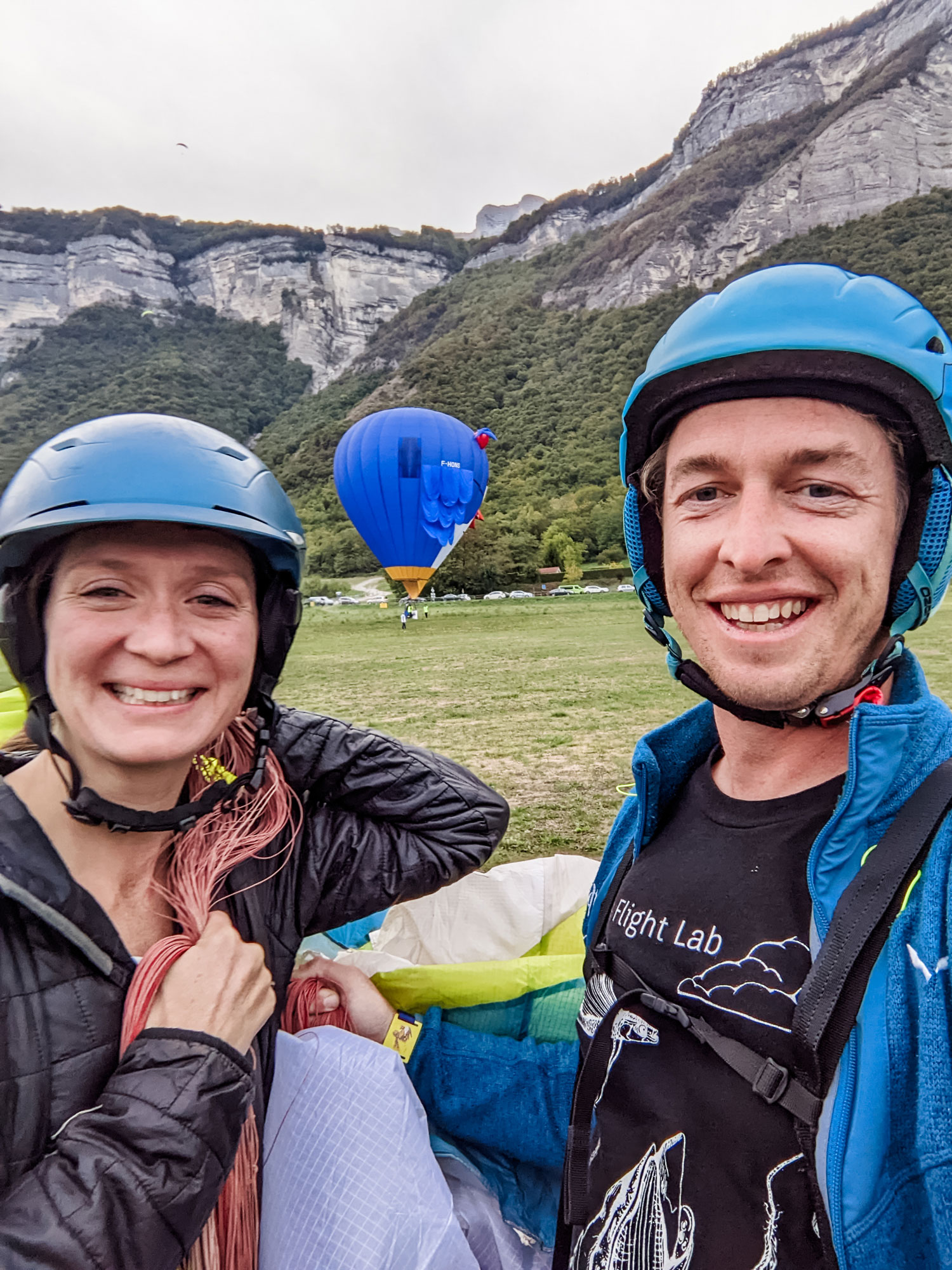 woman and man with helmets and paragliding gear