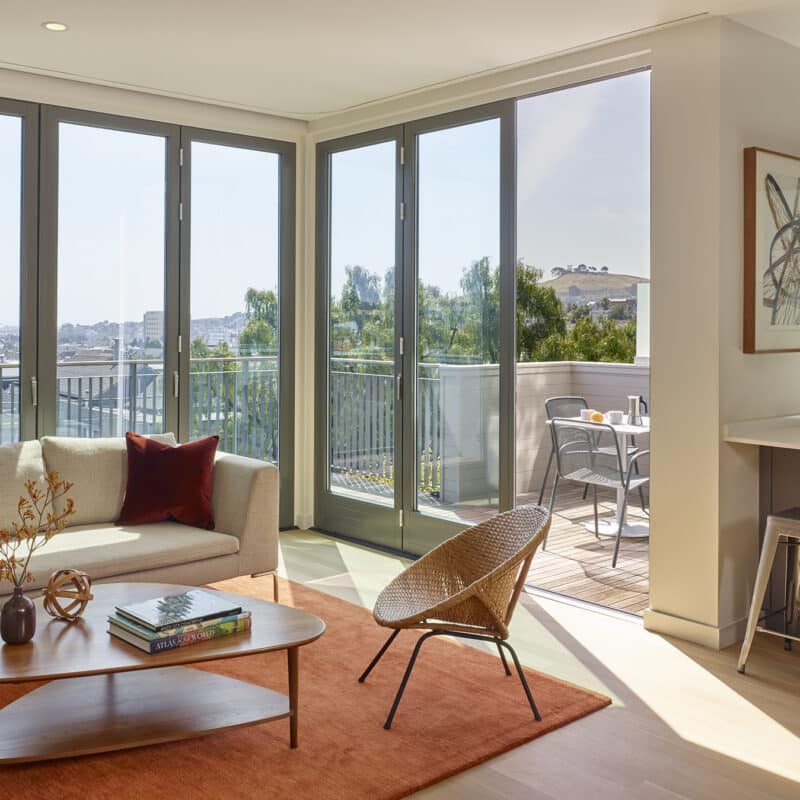 A modern clean San Francisco living room remodeled by AT6 Architecture + Design of San Francisco. Home features sliding accordion doors.